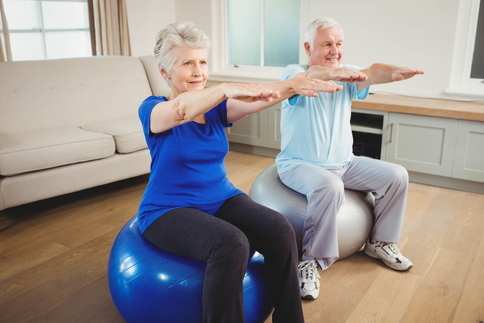 Senior couple exercising on exercise ball