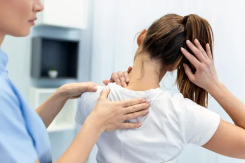 doctor practicing OMT checks a patient's spine