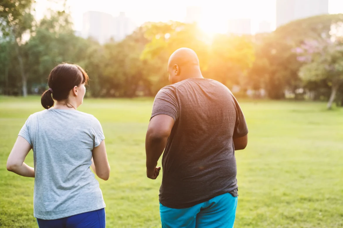 man and woman running side by side through a park